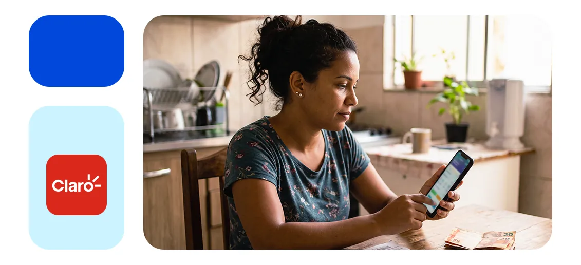 Mulher usando o celular na cozinha, ao lado do logo da Claro